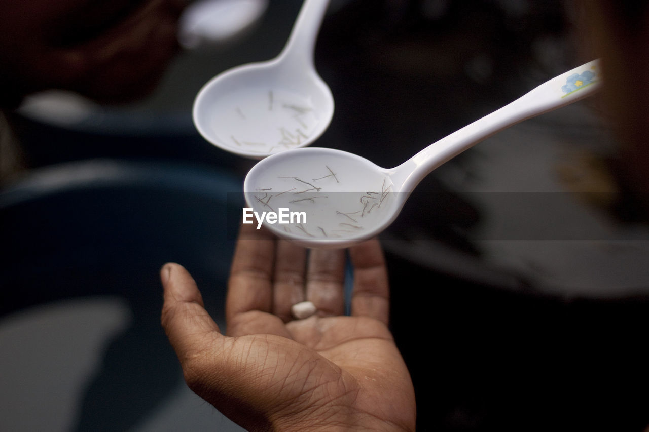 Close-up of person holding food in spoon