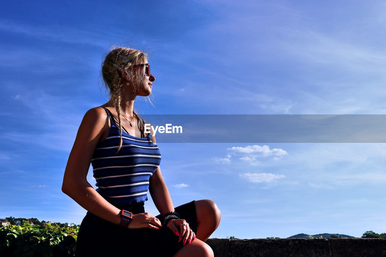 Woman standing against blue sky