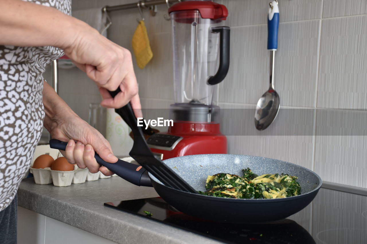 Midsection of woman preparing food in kitchen