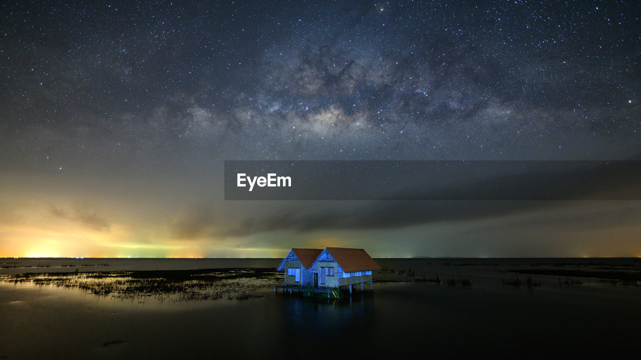 Milky way with twin house near bridge at thale noi, phatthalung, thailand