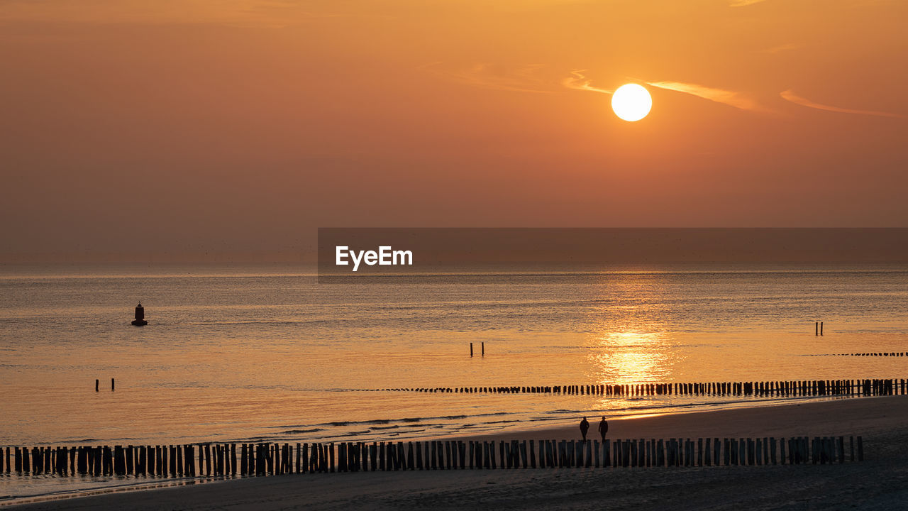 Scenic view of sea against orange sky