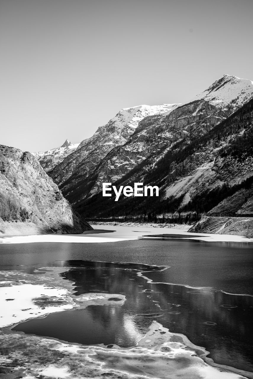 Scenic view of lake and mountains against clear sky