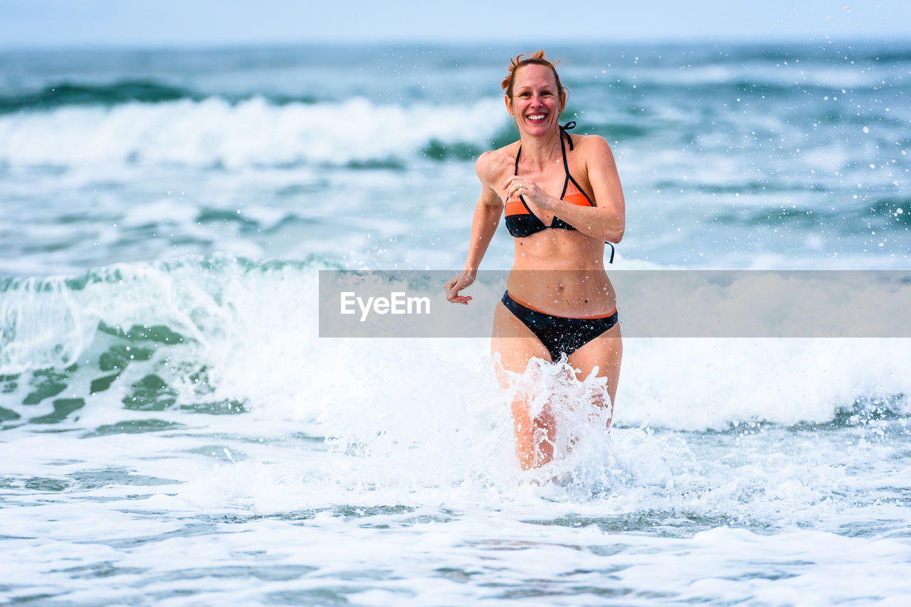 Happy woman wading in sea