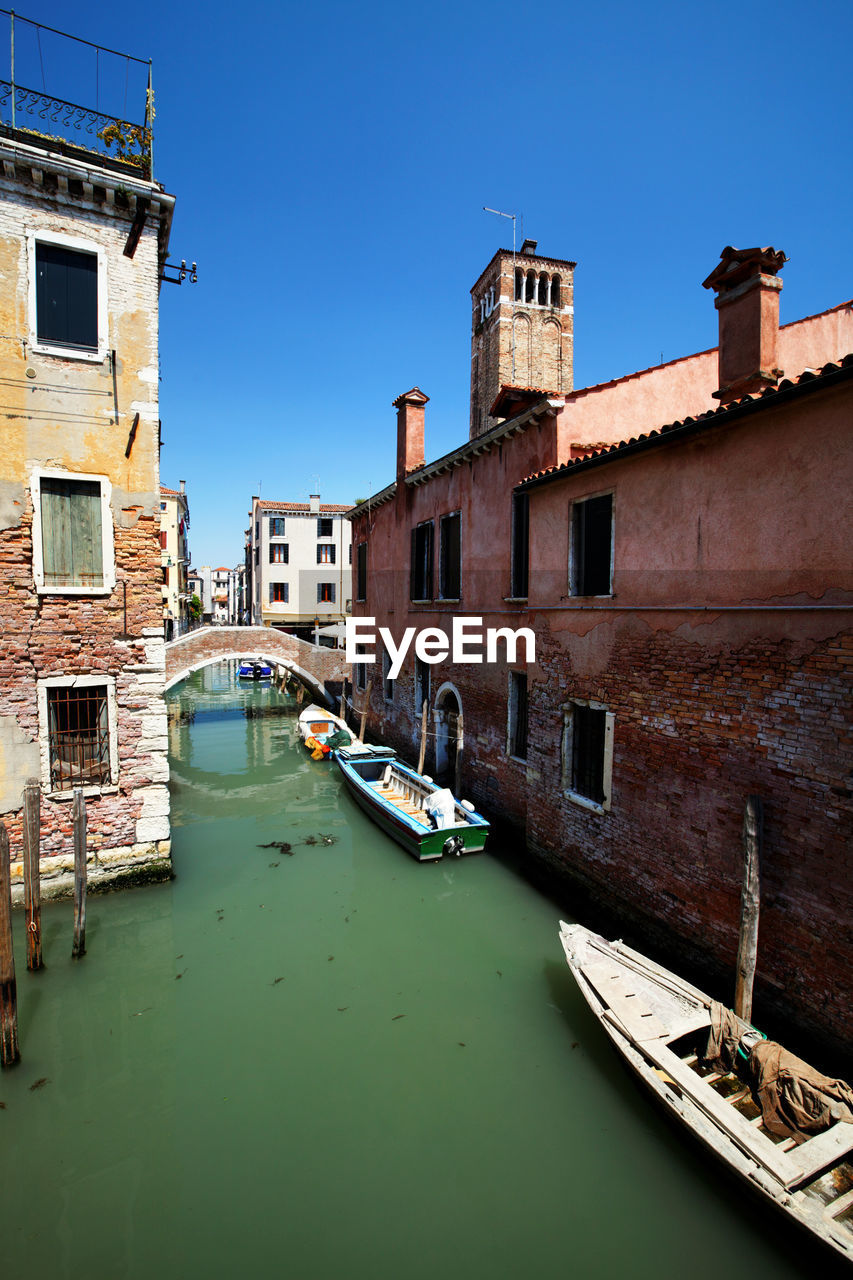 Boats moored on grand canal amidst buildings