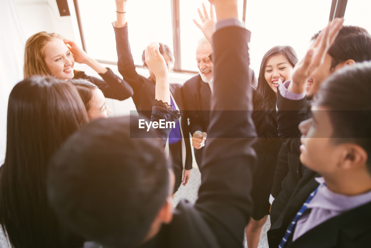 High angle view of business people with arms raised