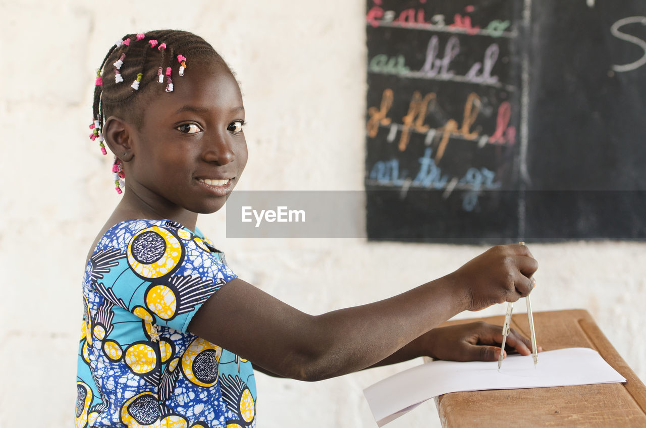 Portrait of smiling girl studying on table