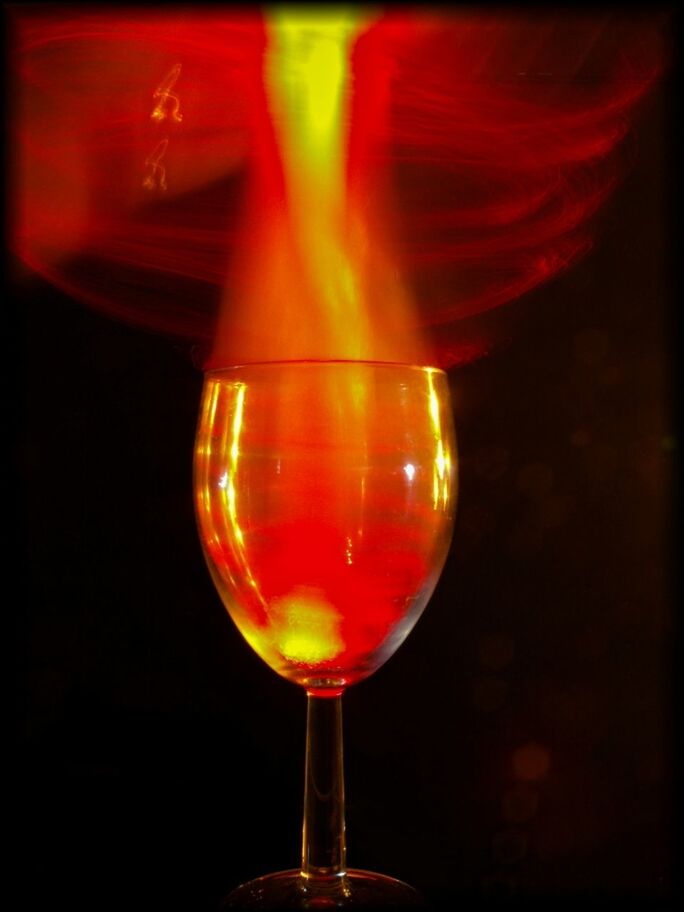 CLOSE-UP OF LIT CANDLES IN THE DARK