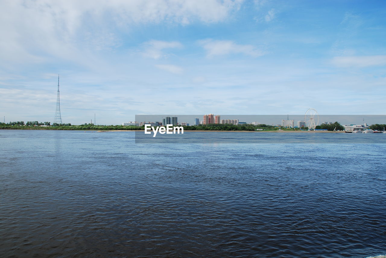 SEA BY BUILDINGS AGAINST SKY