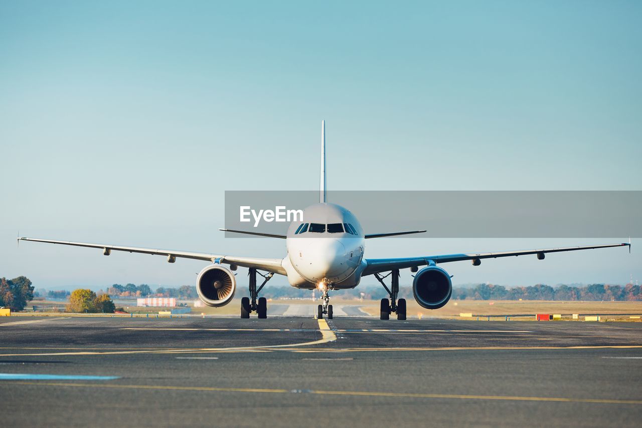 Airplane on runway against clear sky