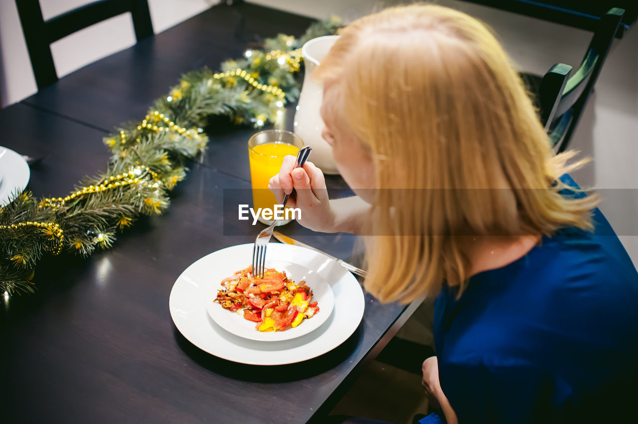 Woman eating food at home during christmas