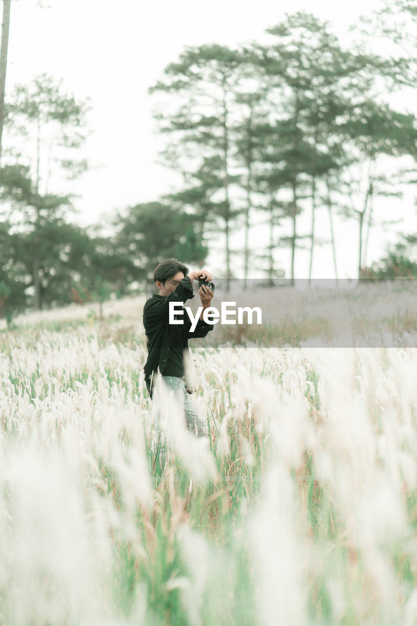 Portrait of man with his camera in the middle of white reeds