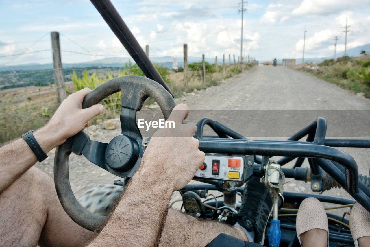 Low section of man driving vehicle on road