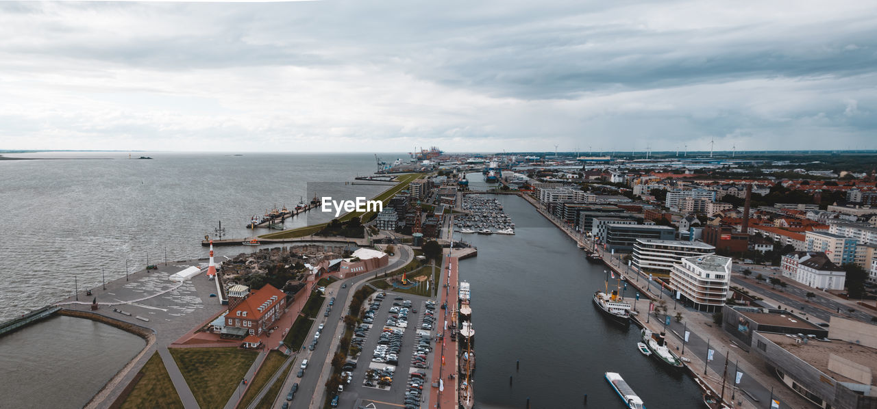 High angle view of city by sea against sky