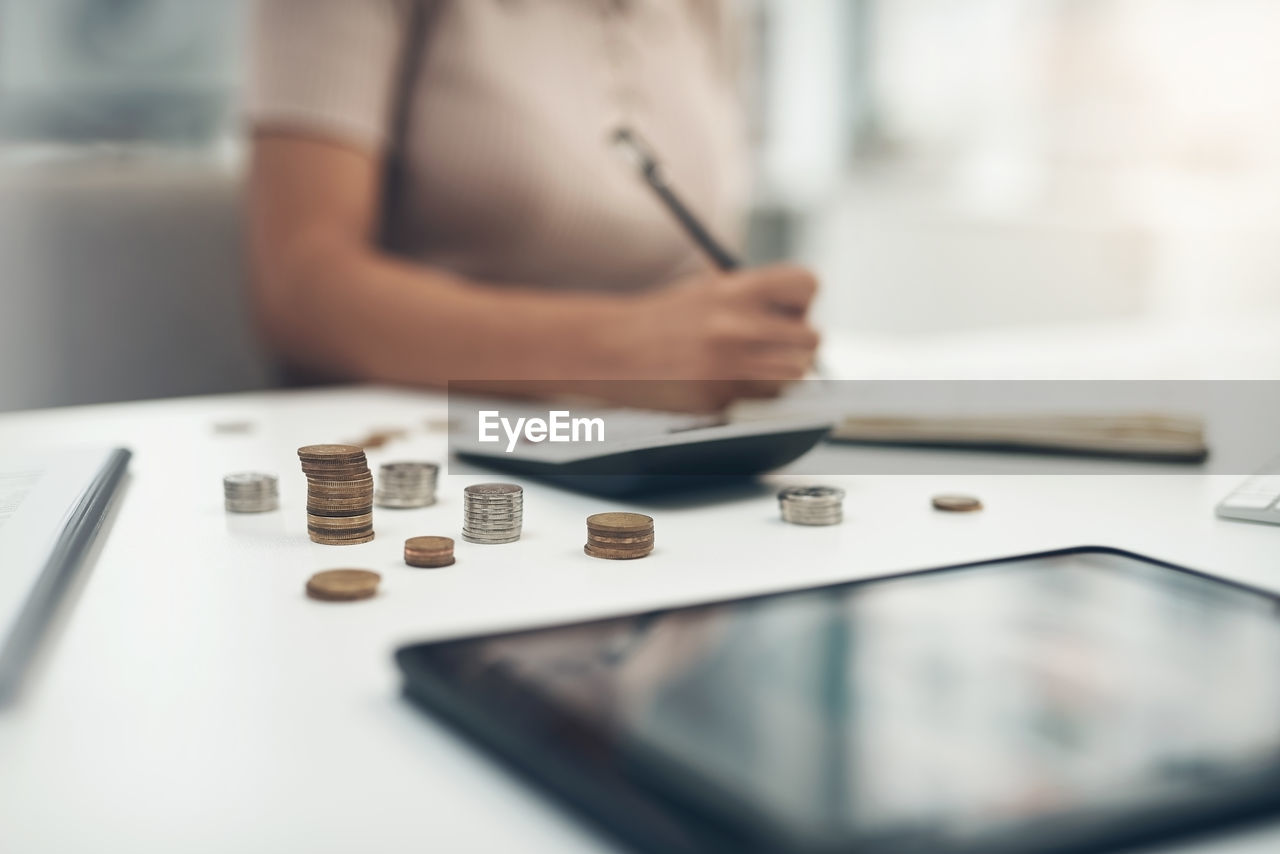 Midsection of woman counting coins at office