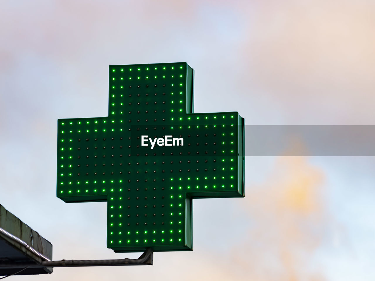 Low angle view of illuminated cross shape against sky in city