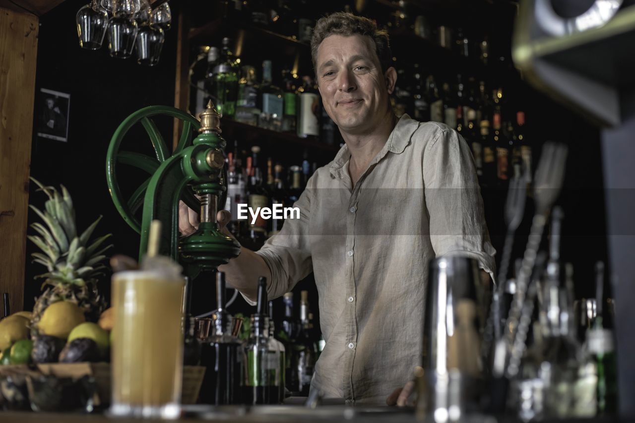 PORTRAIT OF A MAN STANDING IN A BAR