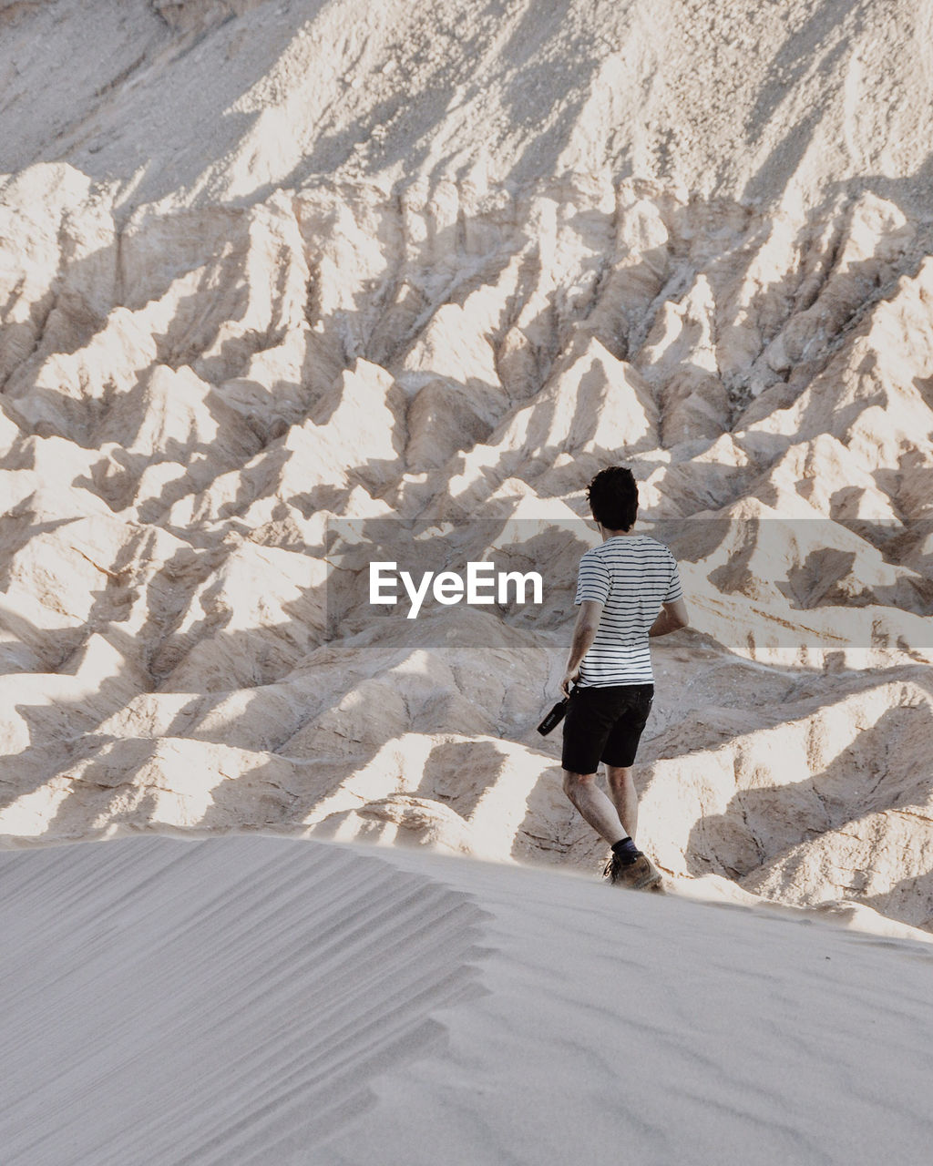 Rear view of person standing on sand