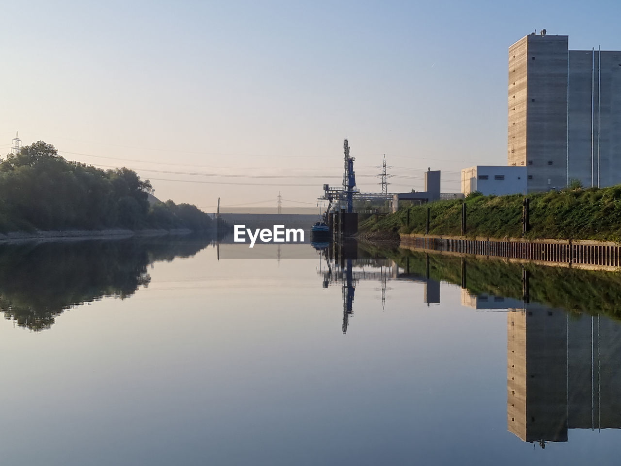 REFLECTION OF BUILDING IN LAKE AGAINST SKY