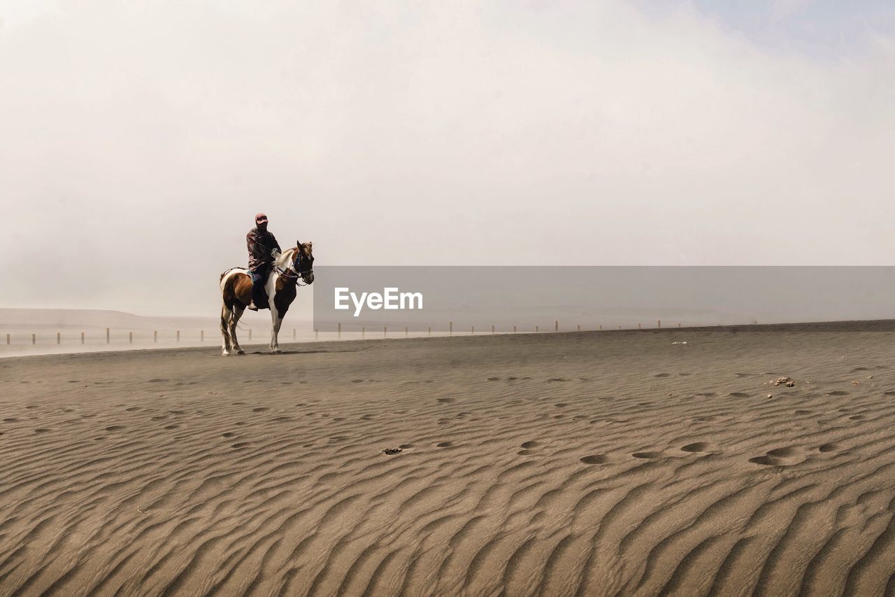 People riding horse on desert 