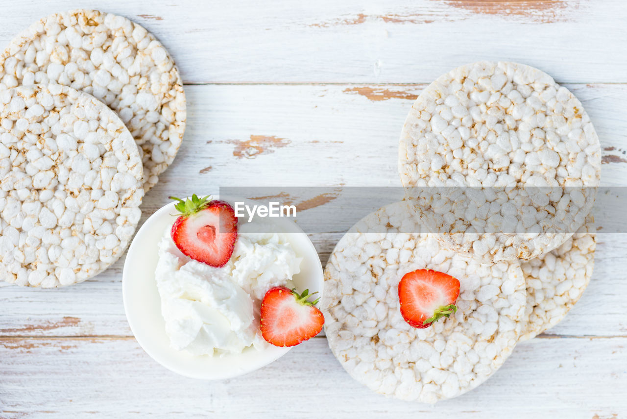 Healthy snack from rice cakes with ingredients nearby such as ricotta cheese and strawberries 