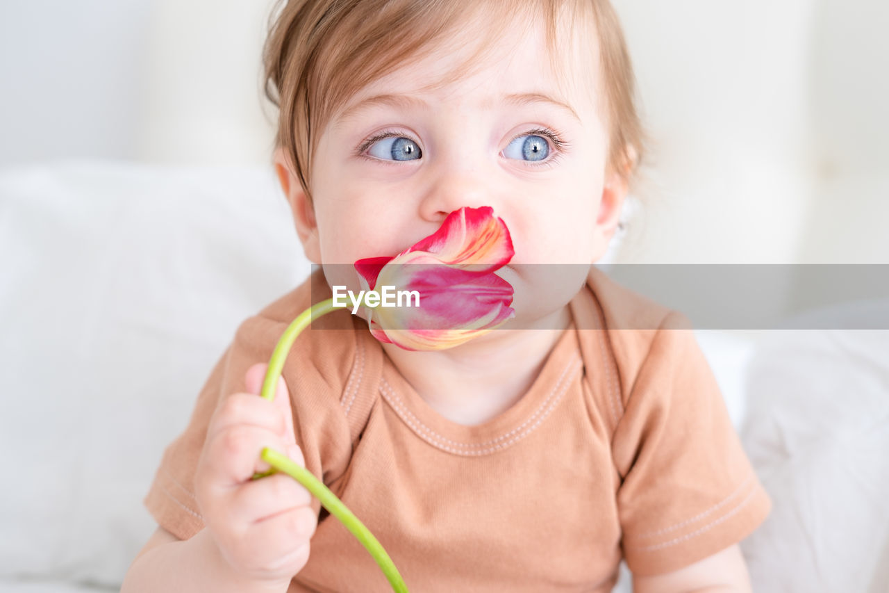 Cute baby girl holding flower