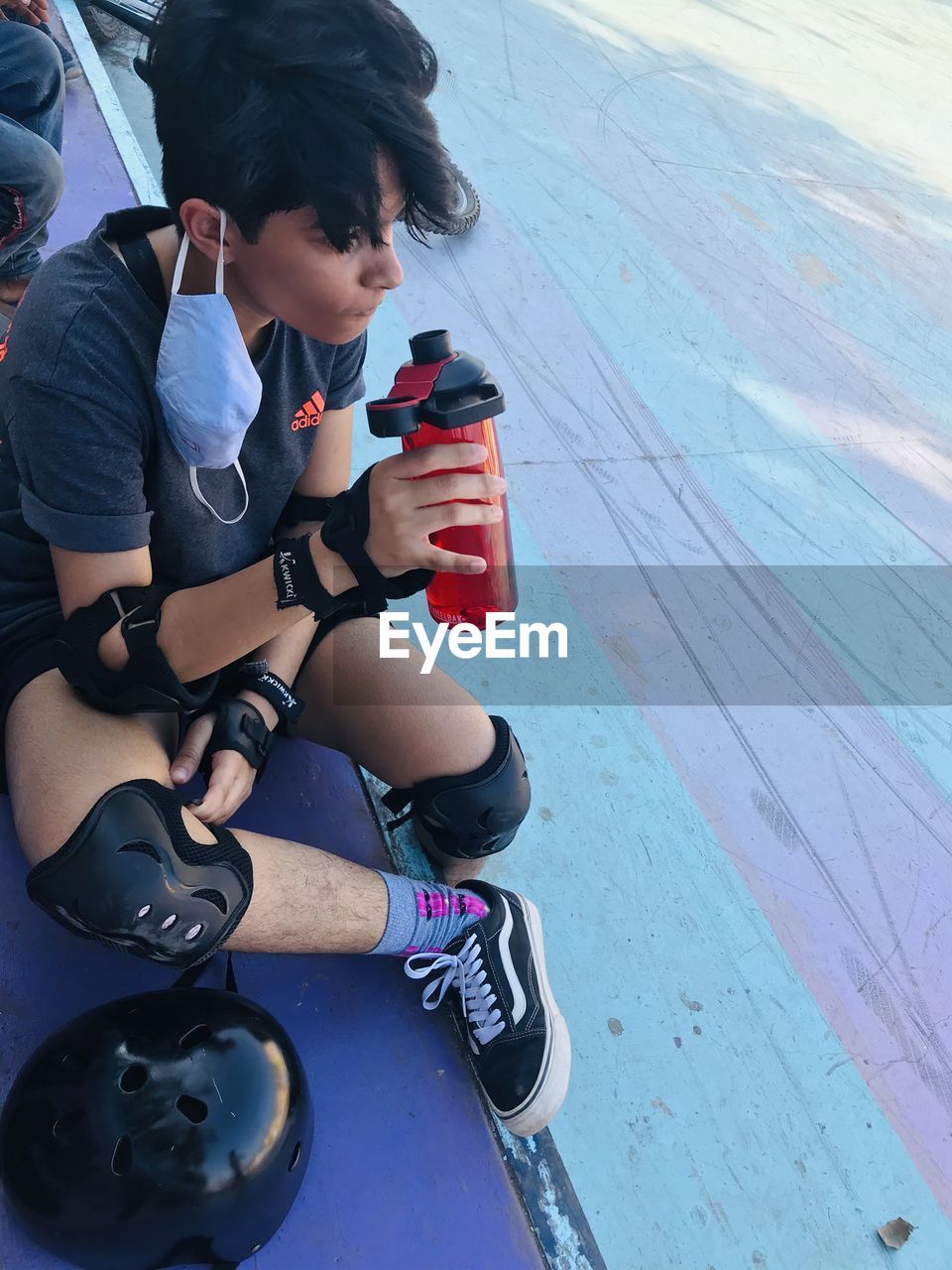 HIGH ANGLE VIEW OF WOMAN LOOKING AT WHILE SITTING IN CONTAINER