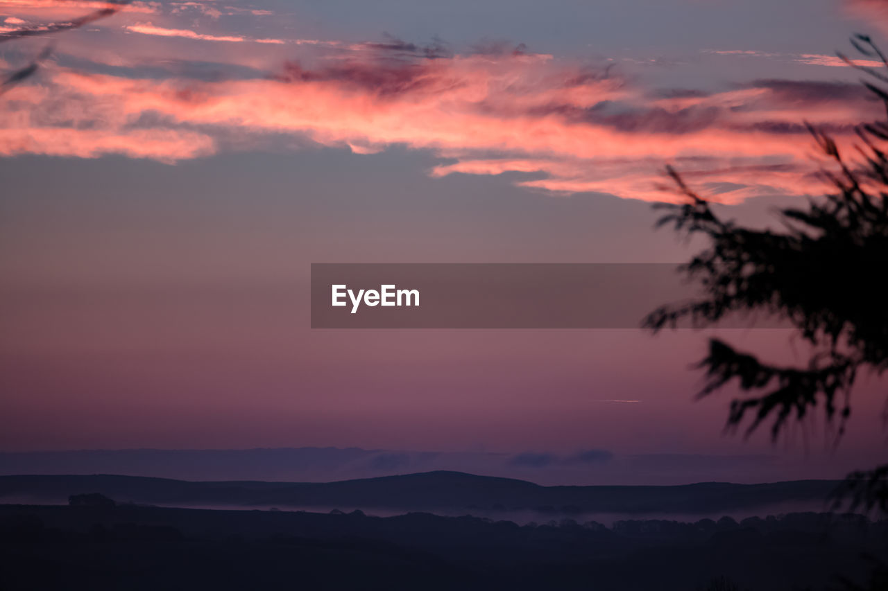 SCENIC VIEW OF SILHOUETTE MOUNTAIN AGAINST SKY AT SUNSET