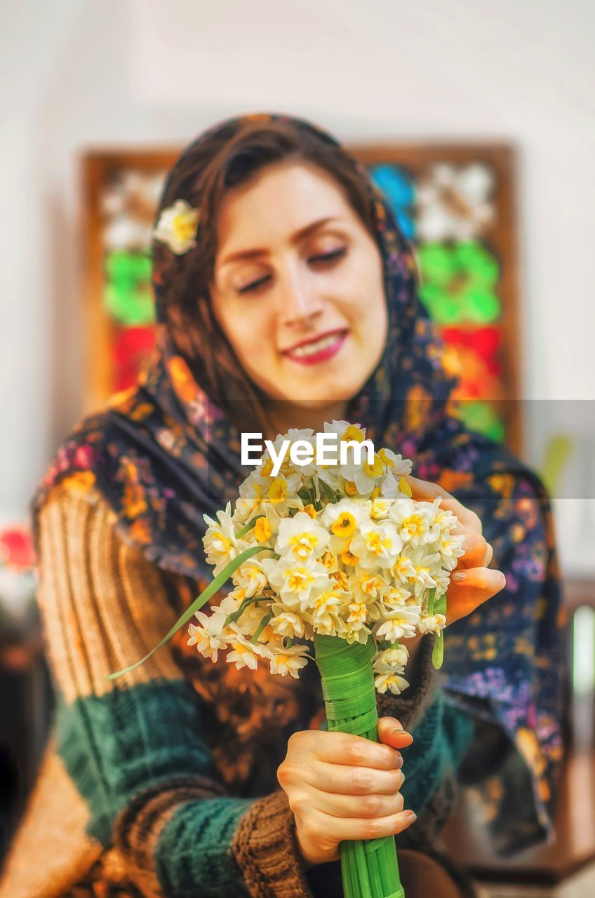 Portrait of smiling young woman holding plant