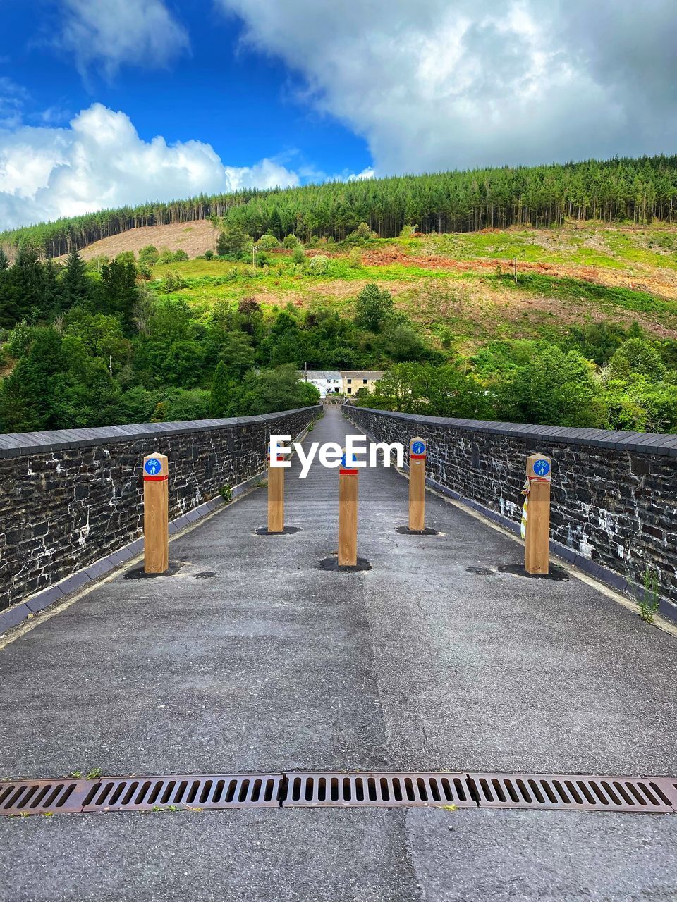 cloud, sky, nature, plant, road, transportation, landscape, environment, no people, architecture, walkway, tree, footpath, outdoors, scenics - nature, land, day, the way forward, travel, city, railing, beauty in nature, street, grass, travel destinations, built structure, mountain, water, sign