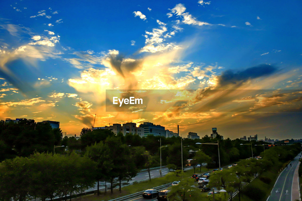 HIGH ANGLE VIEW OF PARKING LOT AGAINST CLOUDY SKY