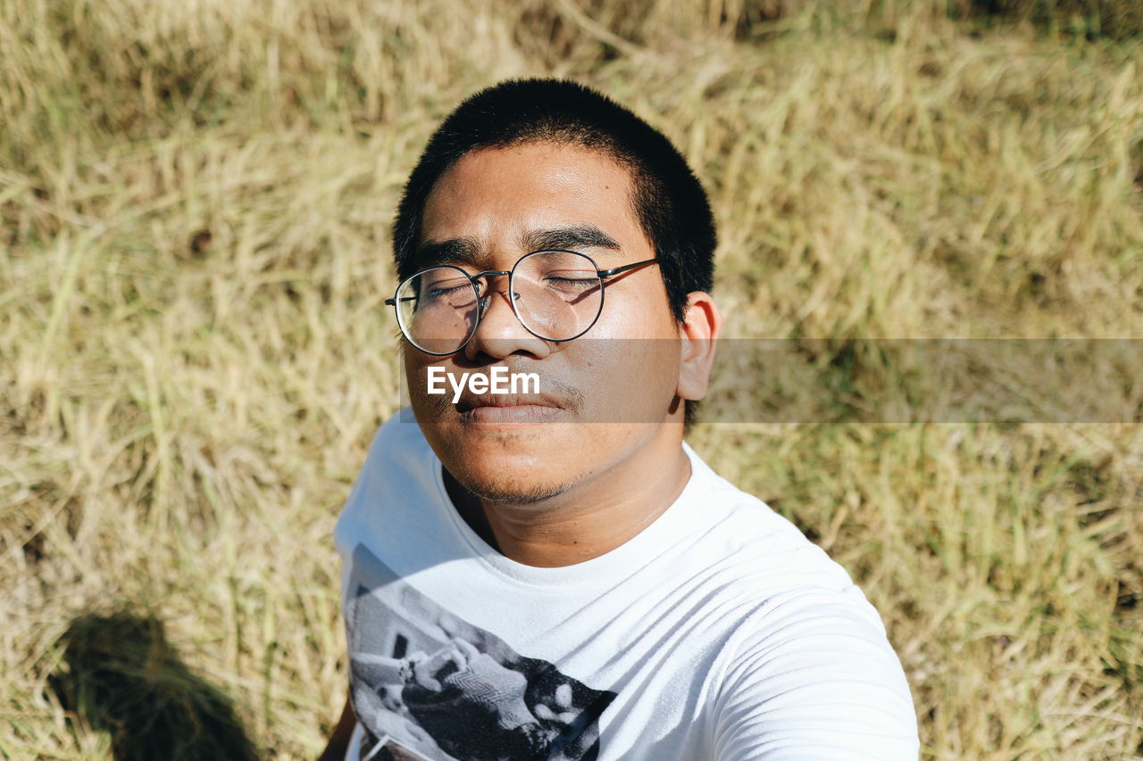 Portrait of young man wearing eyeglasses on land