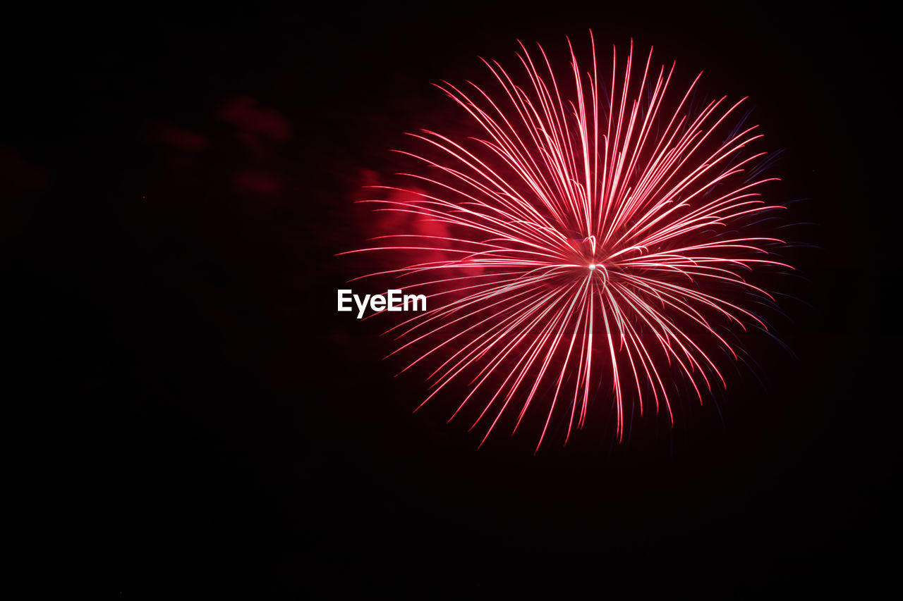 LOW ANGLE VIEW OF FIREWORKS DISPLAY AGAINST SKY AT NIGHT