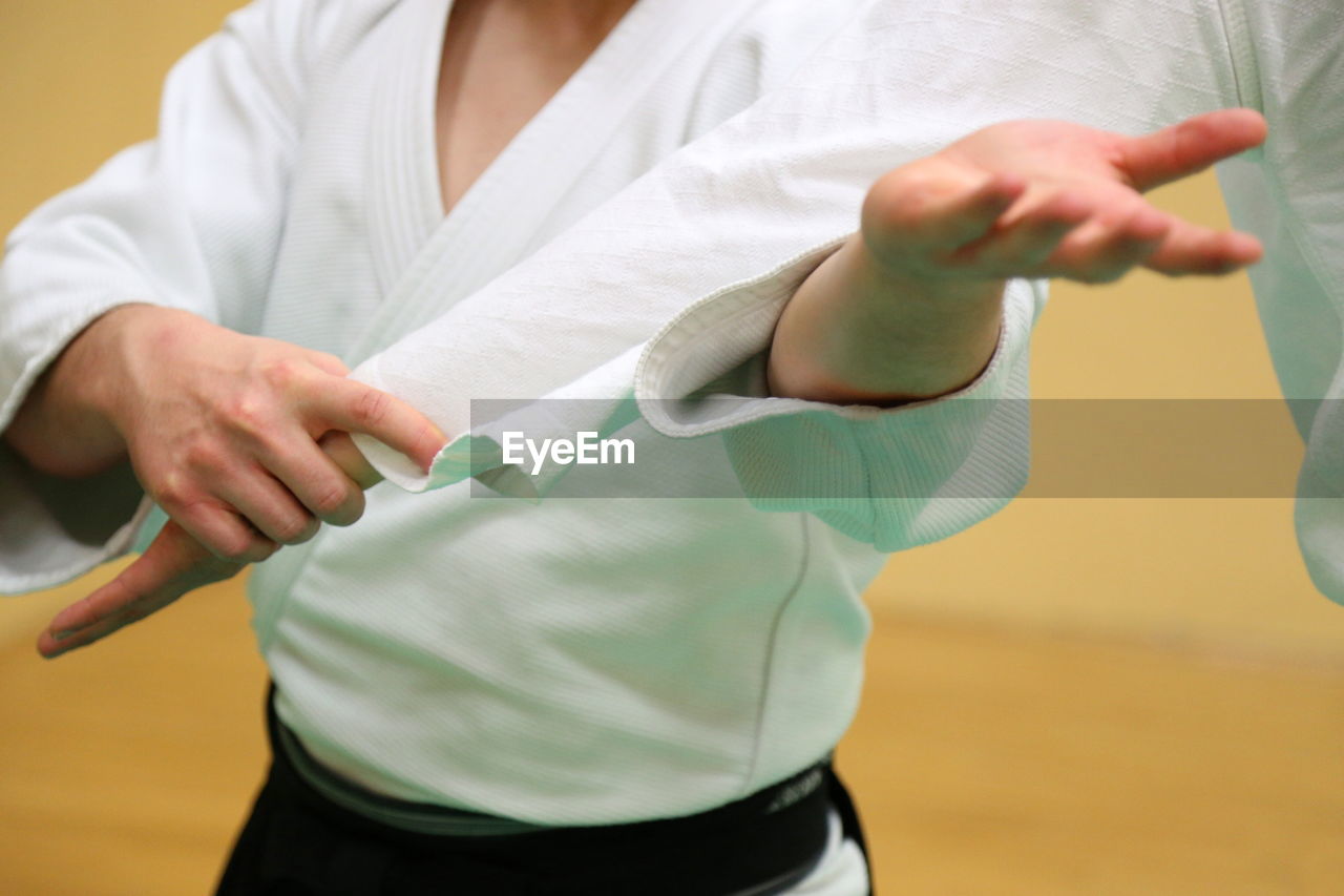 Man with trainer practicing aikido