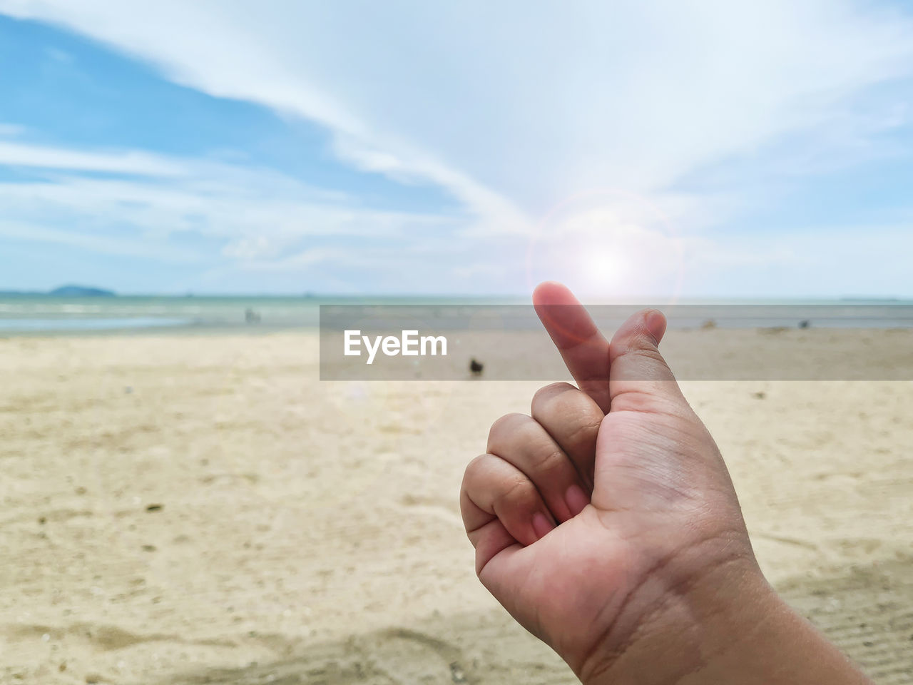 hand, land, sand, sky, beach, sea, nature, finger, one person, cloud, water, horizon, shore, horizon over water, focus on foreground, beauty in nature, body of water, day, holiday, scenics - nature, sunlight, leisure activity, vacation, trip, outdoors, coast, holding, tranquility, personal perspective, adult, tranquil scene