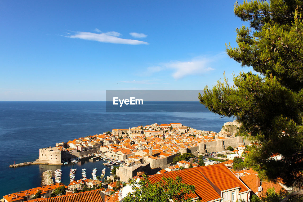 Houses by sea against sky