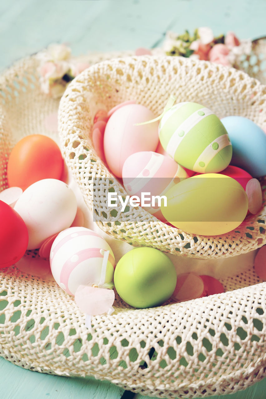 High angle view of colorful easter eggs in hat on table