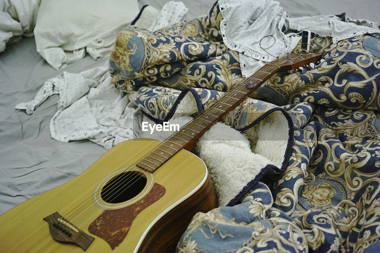 High angle view of guitar on bed