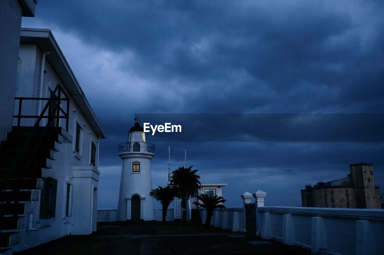 Church amidst buildings against sky at dusk