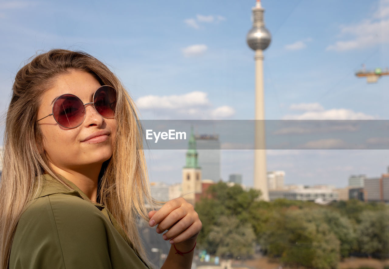 Portrait of smiling young woman against berliner fernsehturm