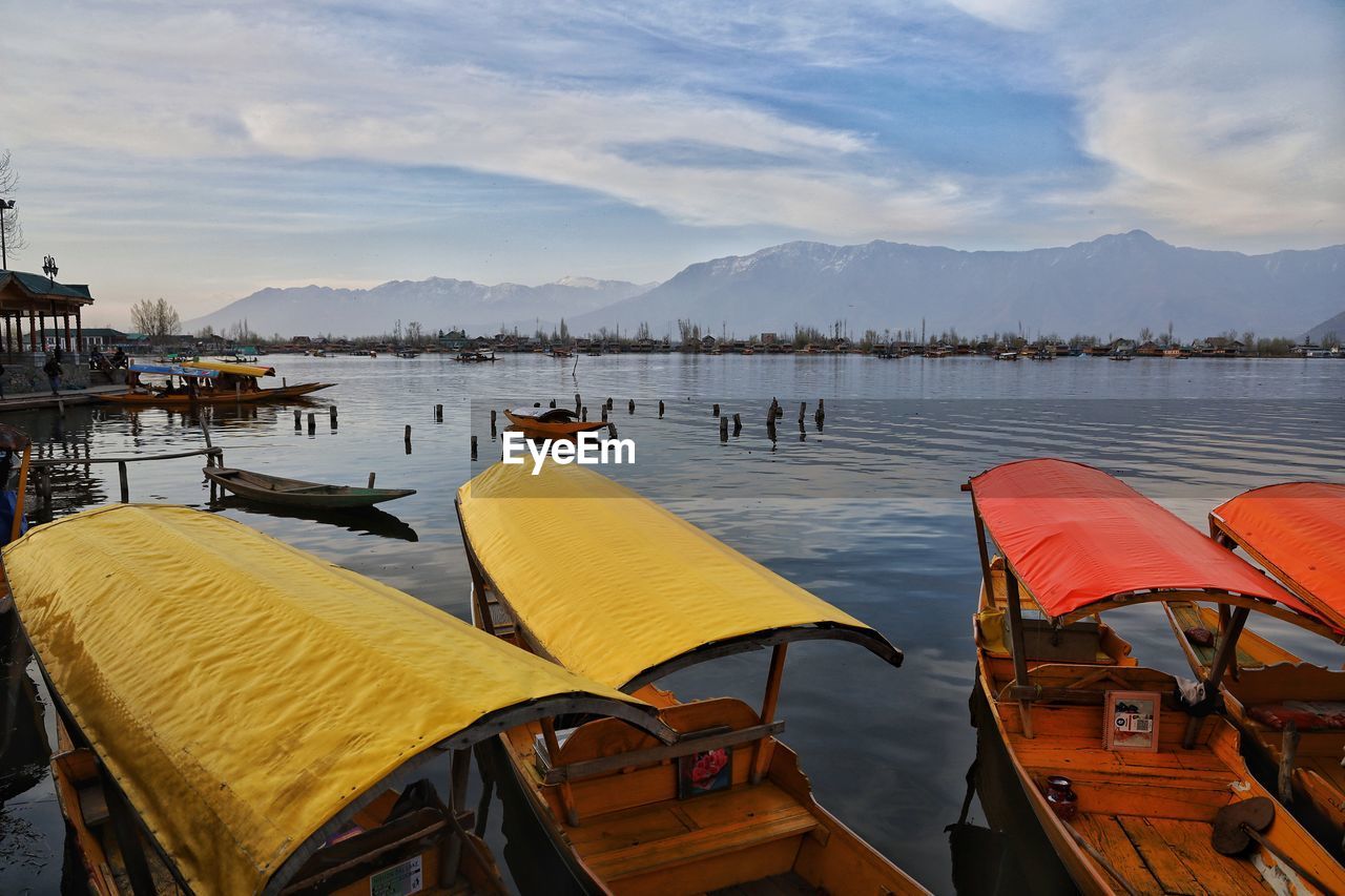 Boats moored in lake against sky, shikara at dal lake srinagar kashmir march 2021