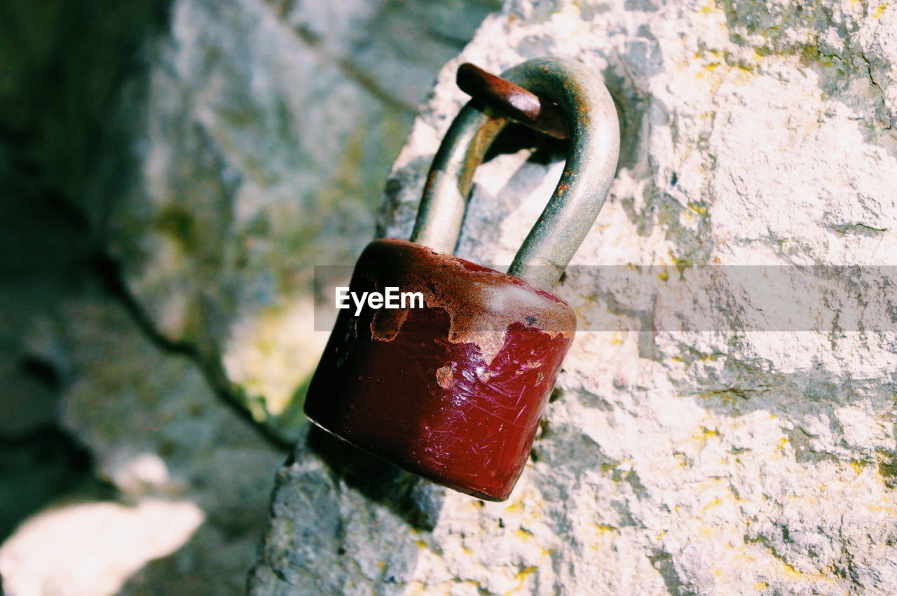 Close-up of padlock on stone wall