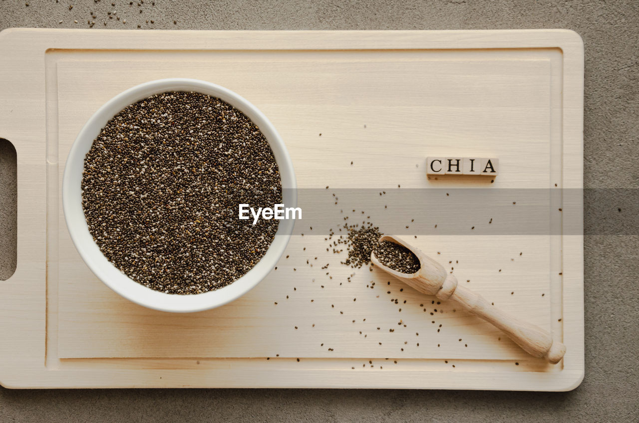 Chia seeds on a wooden board with a spoon and an inscription,