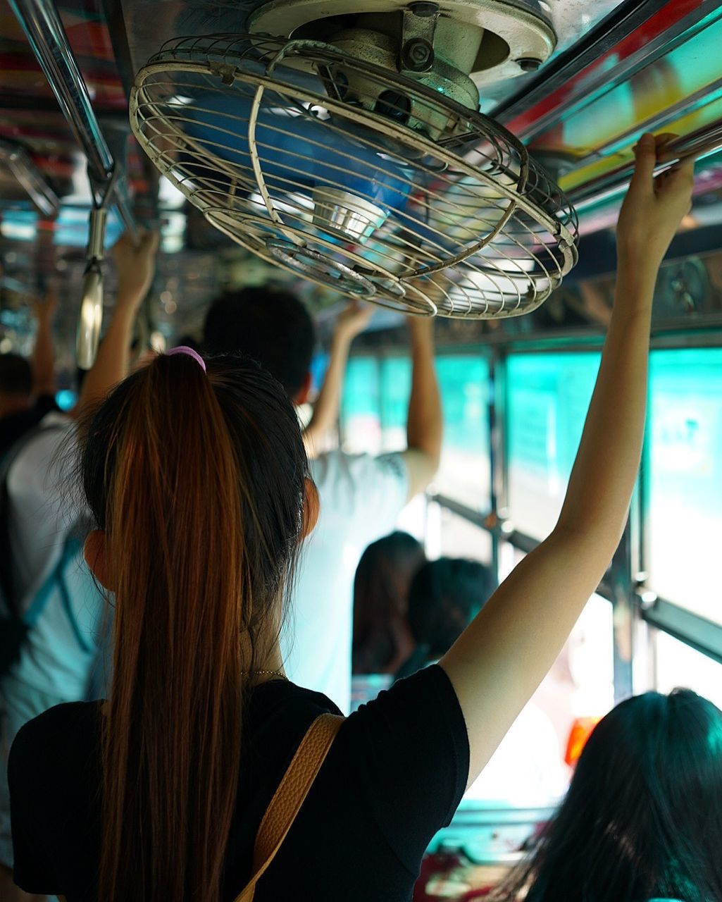 Rear view of woman standing in bus