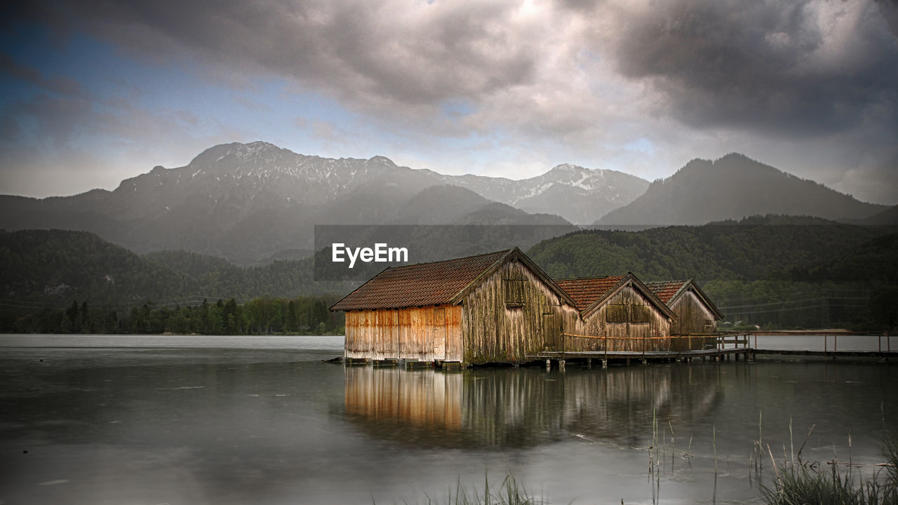 Scenic view of lake by buildings against mountains