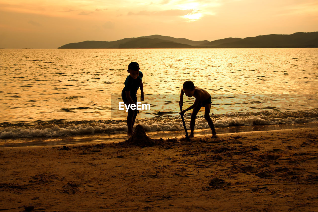 SILHOUETTE PEOPLE ON BEACH DURING SUNSET