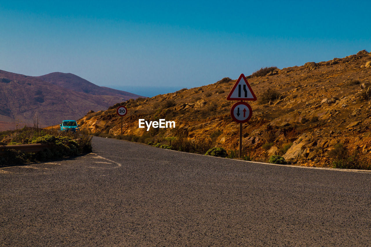 ROAD SIGN AGAINST BLUE SKY