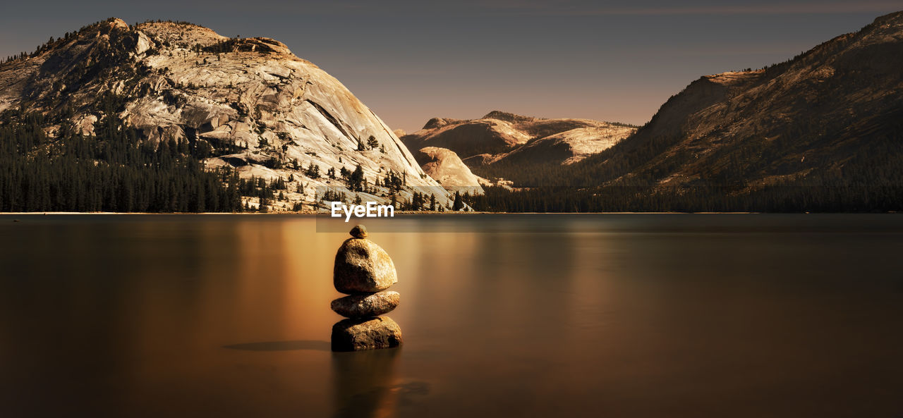 Stacked stones on calm lake against mountains at yosemite national park
