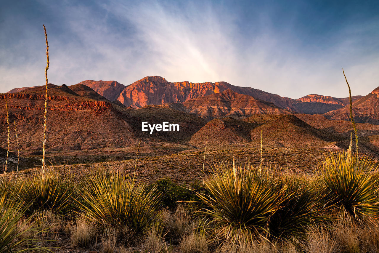 Scenic view of land and mountains against sky