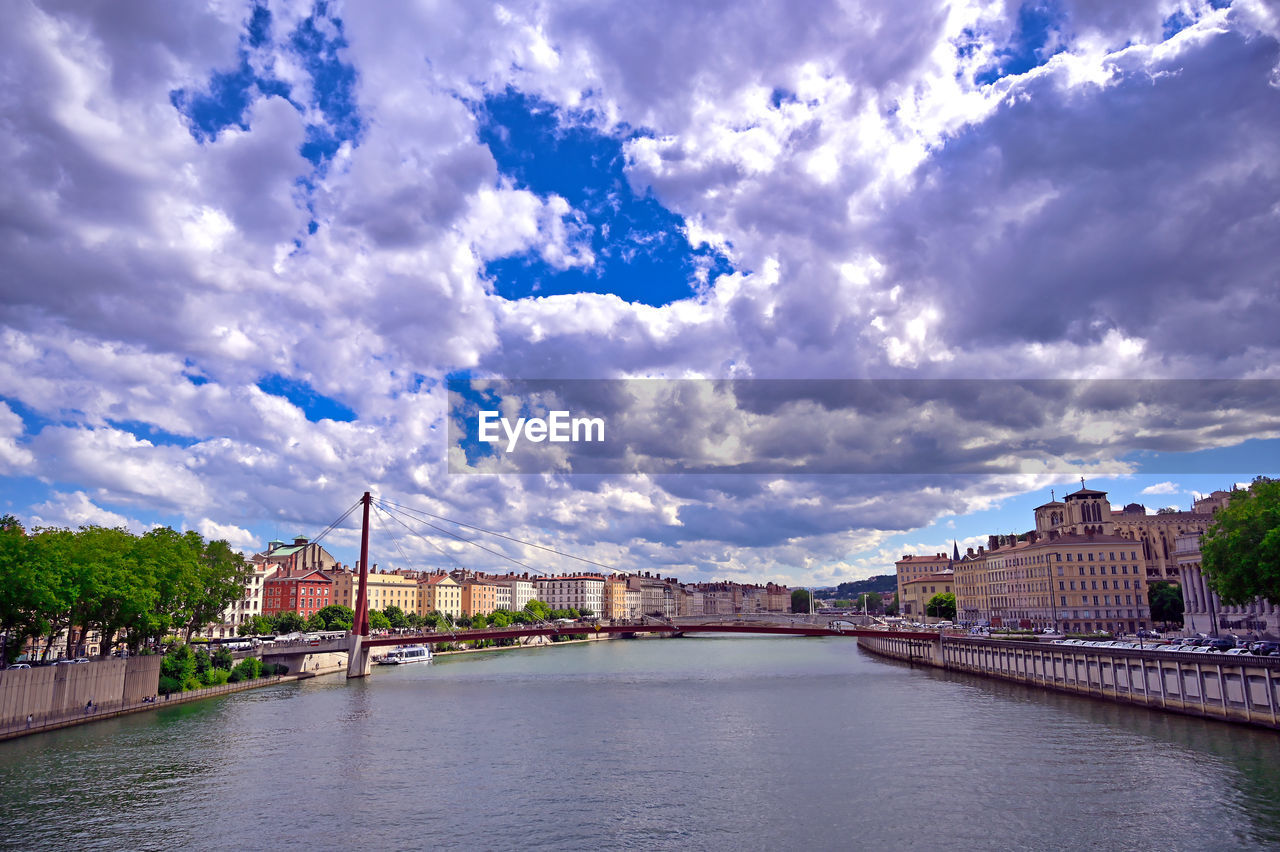 ARCH BRIDGE OVER RIVER AGAINST BUILDINGS