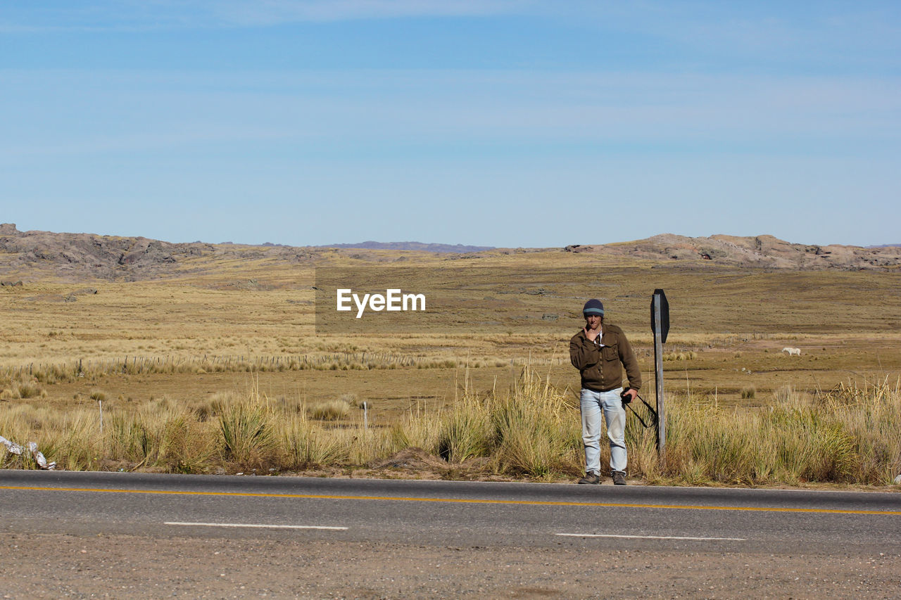 Man standing on road against landscape